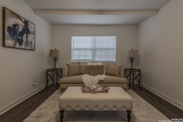 living room featuring beamed ceiling, baseboards, and wood finished floors
