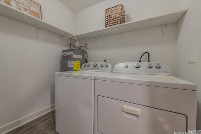 washroom featuring laundry area, washing machine and dryer, baseboards, dark wood-style floors, and water heater