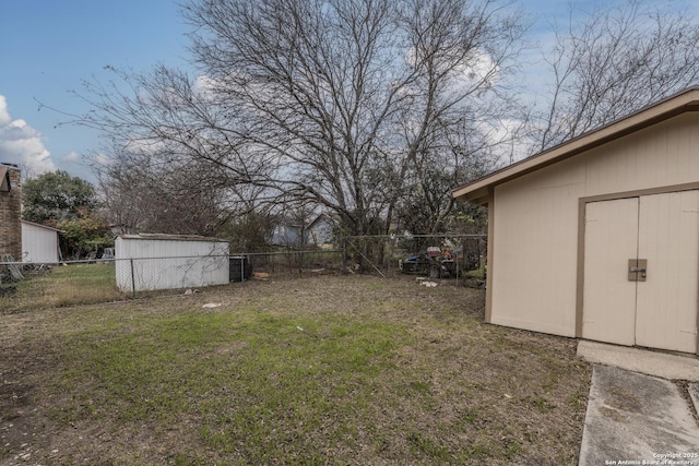 view of yard with an outdoor structure, a fenced backyard, and a storage shed