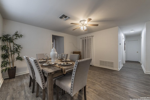 dining space with baseboards, ceiling fan, visible vents, and dark wood finished floors
