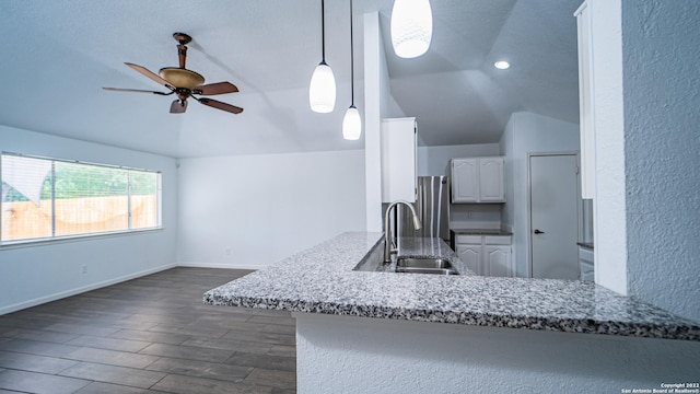 kitchen featuring a sink, white cabinets, ceiling fan, and vaulted ceiling