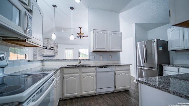 kitchen featuring a sink, white appliances, white cabinetry, and dark wood-type flooring