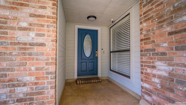 doorway to property featuring brick siding
