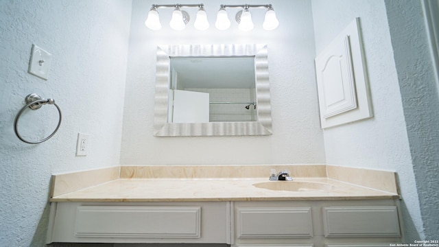 bathroom with vanity and a textured wall