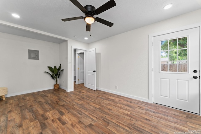 interior space featuring wood finished floors, baseboards, recessed lighting, electric panel, and a ceiling fan