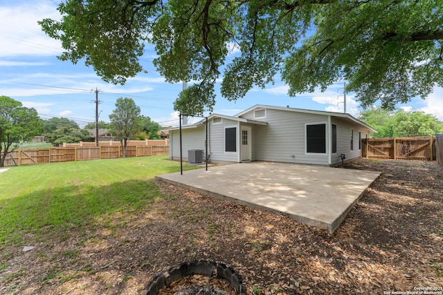 back of property with a yard, a patio, central AC, and a fenced backyard