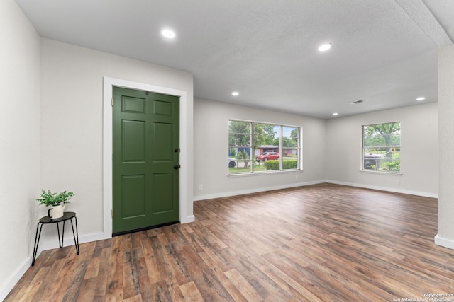 interior space featuring recessed lighting, baseboards, and wood finished floors