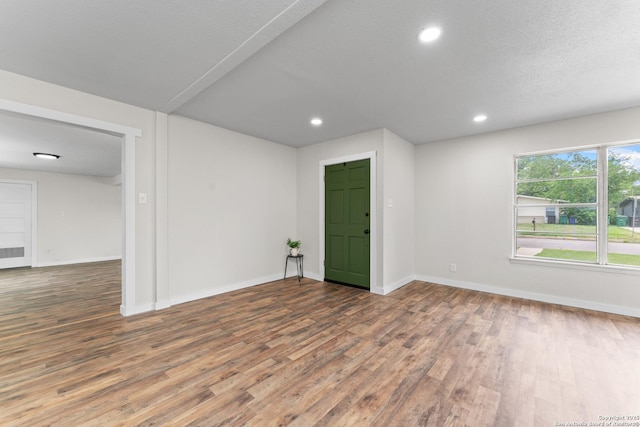spare room featuring baseboards and wood finished floors