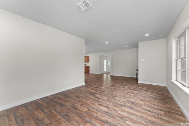 empty room featuring baseboards, recessed lighting, wood finished floors, and visible vents