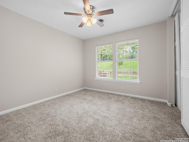 empty room featuring carpet floors, baseboards, visible vents, and ceiling fan
