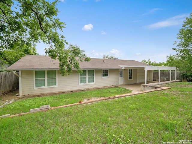 back of property with fence, a lawn, and a patio area