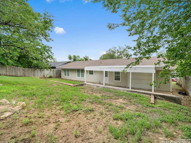 back of house featuring a yard and fence private yard