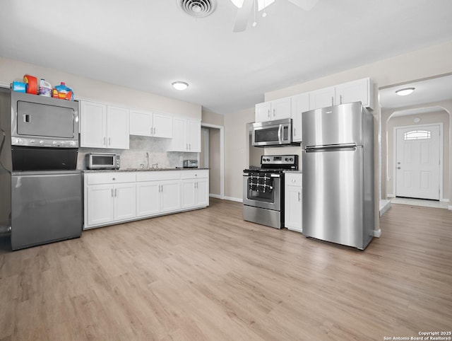 3354 Bob Billa, San Antonio, TX 78223 - kitchen with visible vents, appliances with stainless steel finishes, stacked washer and clothes dryer, and light wood-style floors