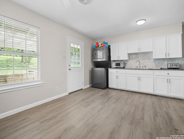 kitchen with baseboards, a sink, and light wood finished floors