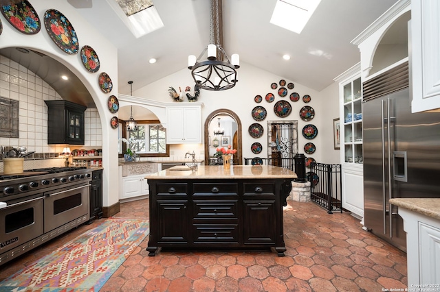 220 N School St, Boerne, TX 78006 - kitchen featuring white cabinets, high quality appliances, an inviting chandelier, tasteful backsplash, and beamed ceiling