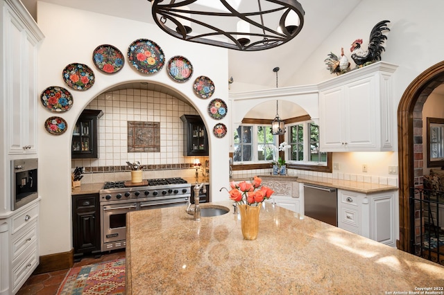 220 N School St, Boerne, TX 78006 - kitchen featuring an inviting chandelier, light stone countertops, white cabinets, tasteful backsplash, and appliances with stainless steel finishes