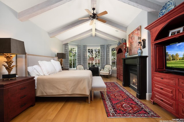 220 N School St, Boerne, TX 78006 - bedroom with light wood-type flooring, lofted ceiling with beams, a glass covered fireplace, and a ceiling fan