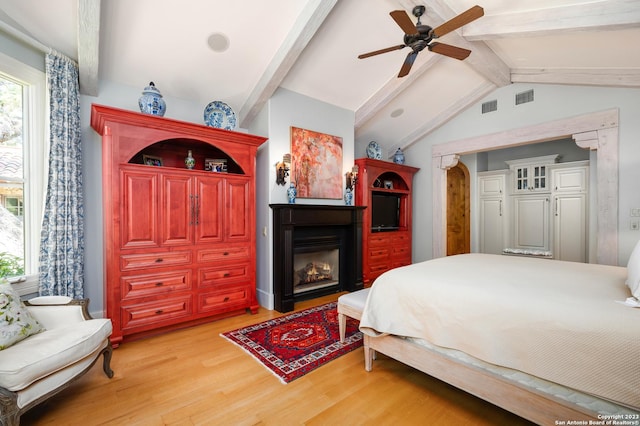 220 N School St, Boerne, TX 78006 - bedroom with light wood-style floors, vaulted ceiling with beams, a glass covered fireplace, and visible vents