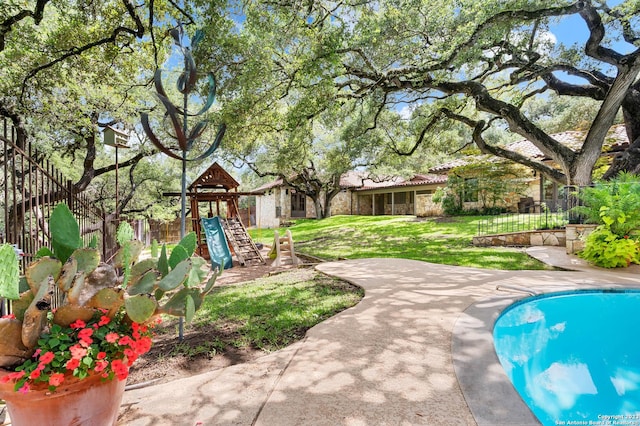 220 N School St, Boerne, TX 78006 - view of swimming pool featuring a playground, fence, a fenced in pool, and a yard