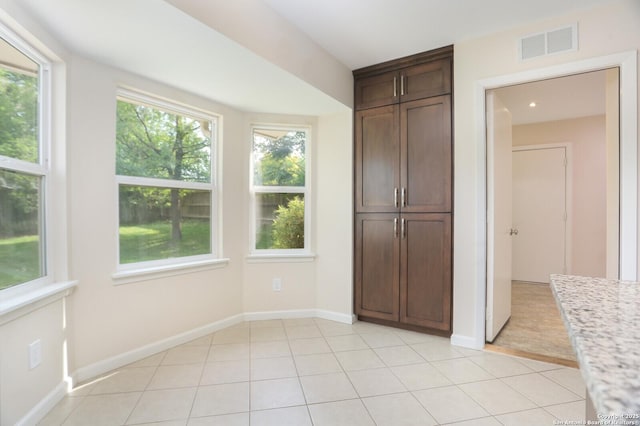 unfurnished bedroom featuring light tile patterned floors, baseboards, a closet, and visible vents