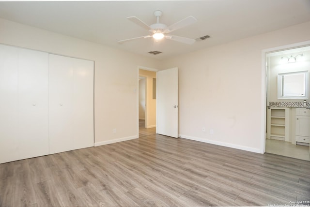 unfurnished bedroom with light wood-style floors, baseboards, visible vents, and a closet