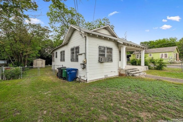 view of front of home featuring a front yard, a storage shed, an outbuilding, a gate, and fence