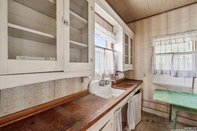 bathroom with vanity, a wealth of natural light, and wallpapered walls