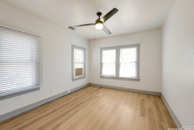unfurnished room with baseboards, ceiling fan, light wood finished floors, and visible vents