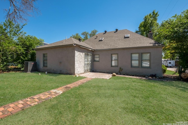 rear view of house with a lawn, stucco siding, a chimney, and a shingled roof