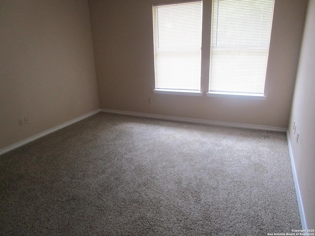 carpeted empty room with baseboards
