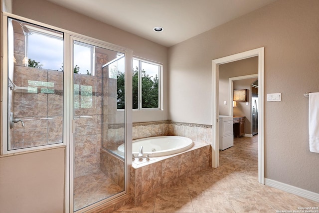 full bathroom with washer / clothes dryer, tile patterned flooring, a shower stall, and a bath