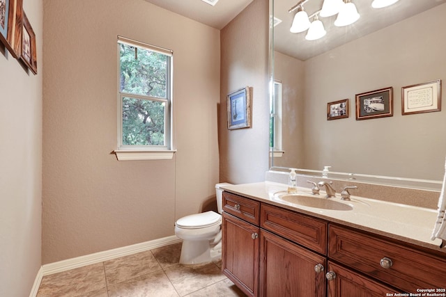 half bath with vanity, tile patterned flooring, an inviting chandelier, toilet, and baseboards