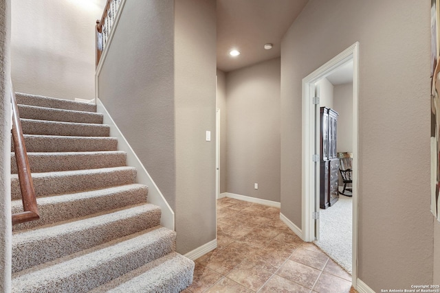 stairway featuring baseboards, recessed lighting, and tile patterned flooring