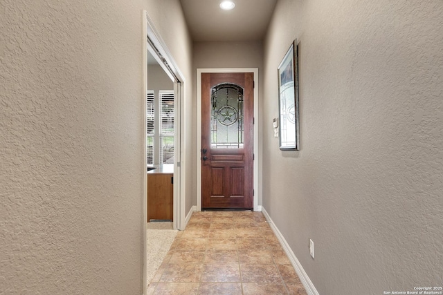 entryway featuring baseboards and a textured wall