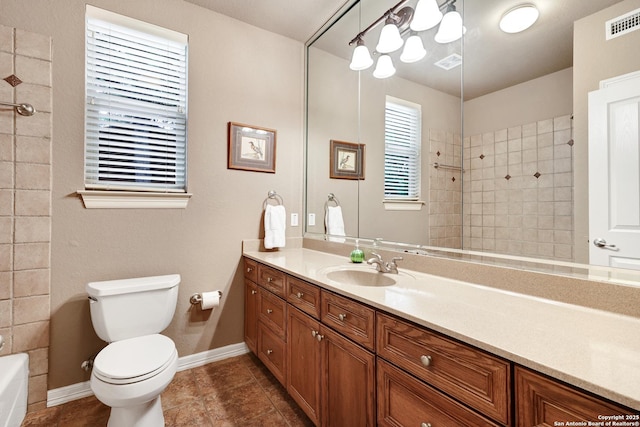 full bath featuring tile patterned floors, visible vents, a tile shower, and vanity