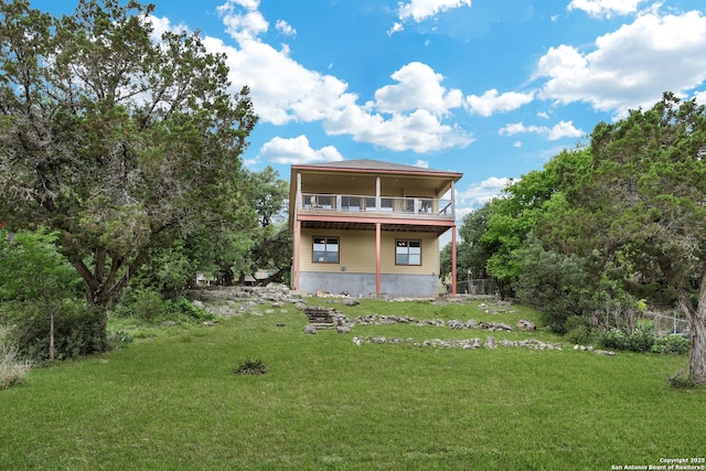 back of house featuring a yard, fence, and a balcony