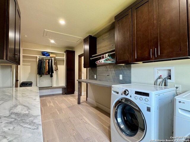 120 Sam Houston, Kerrville, TX 78028 - laundry area featuring cabinet space, washer and clothes dryer, attic access, light wood-type flooring, and baseboards