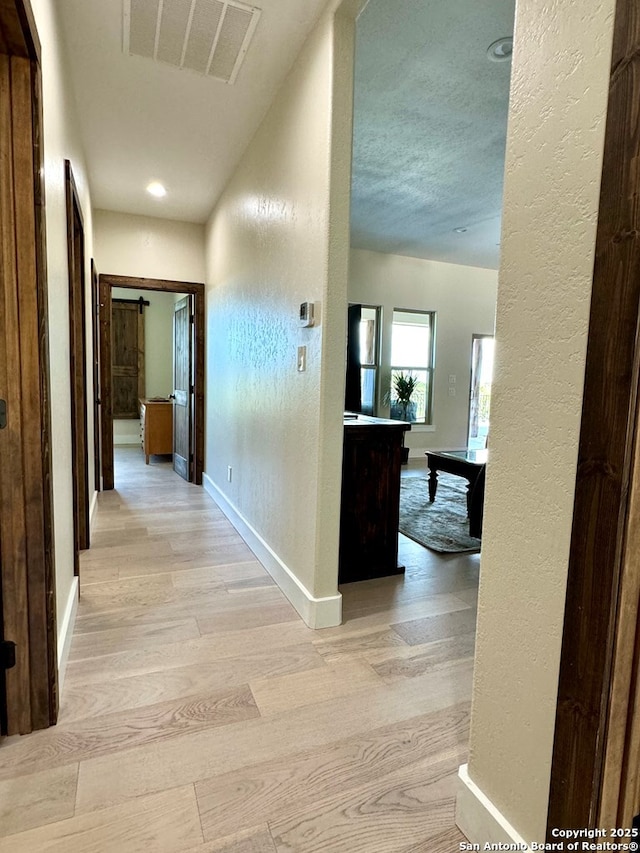 120 Sam Houston, Kerrville, TX 78028 - corridor with baseboards, light wood-type flooring, a textured wall, and recessed lighting