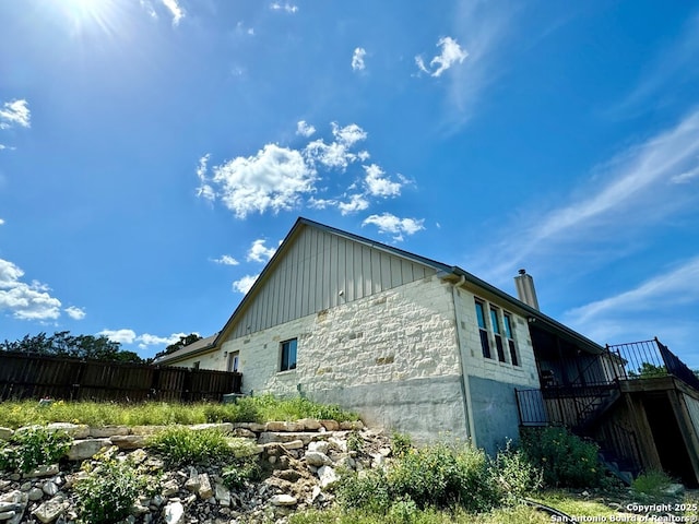 120 Sam Houston, Kerrville, TX 78028 - view of home's exterior with stairway, fence, board and batten siding, and a chimney