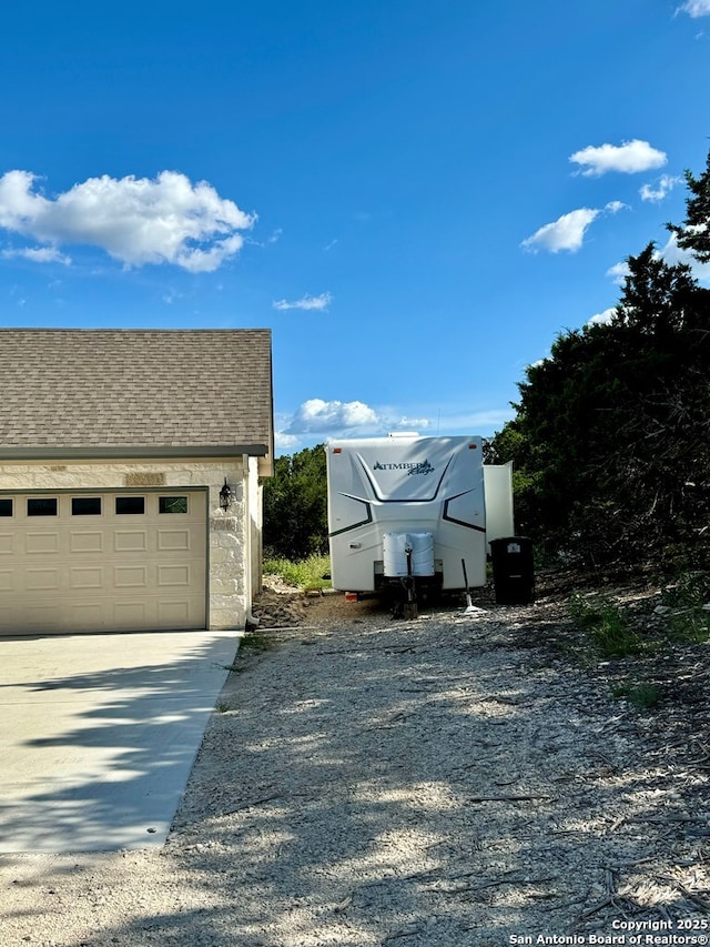 120 Sam Houston, Kerrville, TX 78028 - view of side of home with a shingled roof, driveway, and a garage