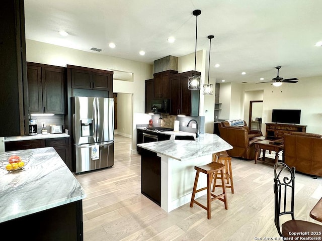 120 Sam Houston, Kerrville, TX 78028 - kitchen featuring stainless steel appliances, a breakfast bar, open floor plan, light wood finished floors, and recessed lighting