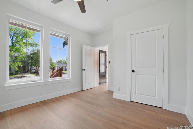 unfurnished bedroom with a ceiling fan, baseboards, and light wood finished floors