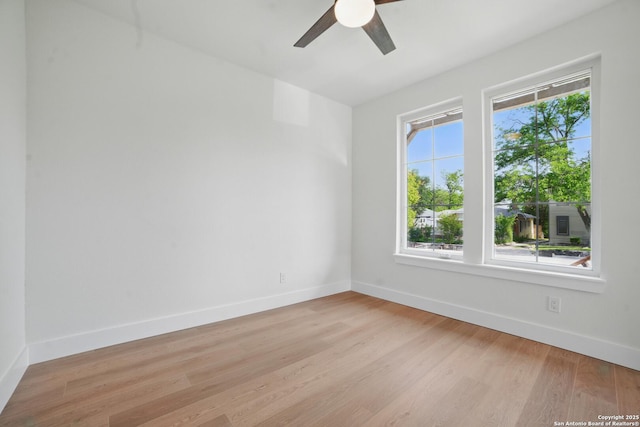 empty room with baseboards, ceiling fan, and light wood finished floors