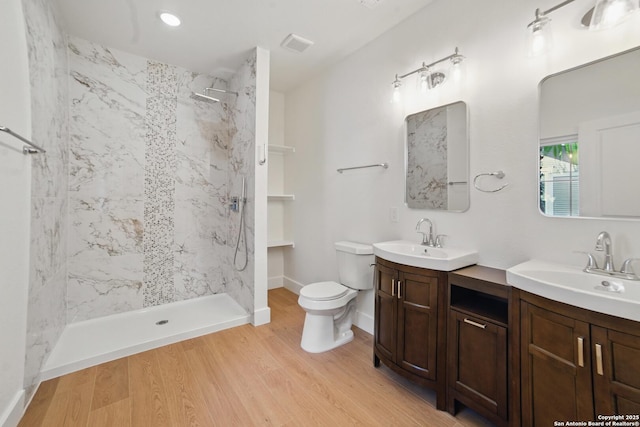 full bath featuring vanity, wood finished floors, toilet, baseboards, and a walk in shower