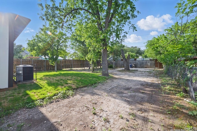 view of yard with a fenced backyard and central AC