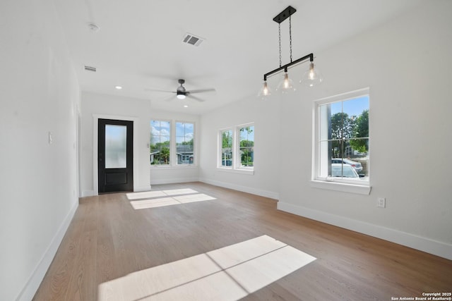 unfurnished living room featuring baseboards, a ceiling fan, wood finished floors, and visible vents