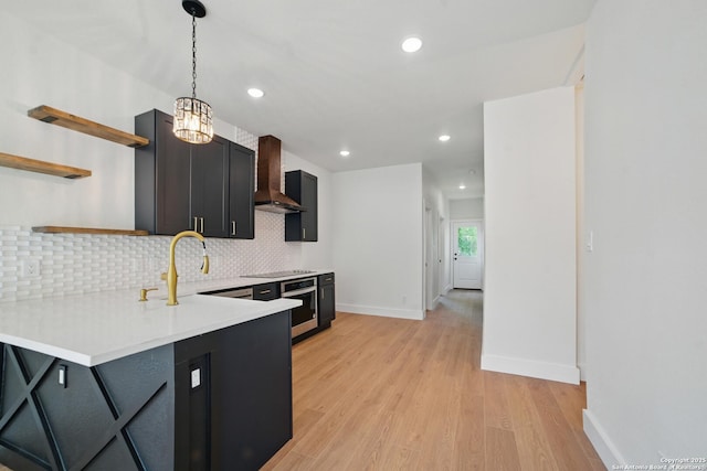kitchen featuring backsplash, open shelves, light countertops, light wood-style floors, and wall chimney exhaust hood