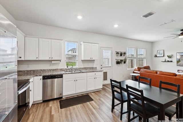 kitchen featuring a ceiling fan, range with electric stovetop, visible vents, stainless steel dishwasher, and a sink