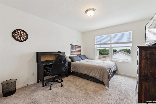 bedroom featuring baseboards, light carpet, and multiple windows