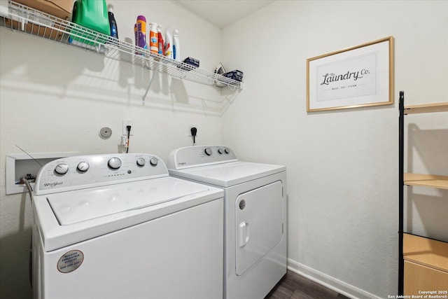 laundry area featuring baseboards, laundry area, washer and clothes dryer, and dark wood-type flooring